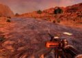 A first-person view in 7 Days to Die showing a player holding a basic, worn firearm while standing on a cracked desert road surrounded by red rocky terrain and cacti under an orange sky